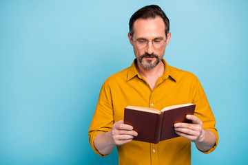 Poster - Portrait of focused man hold paperbook read want study learn new information wear casual style outfit isolated over blue color background