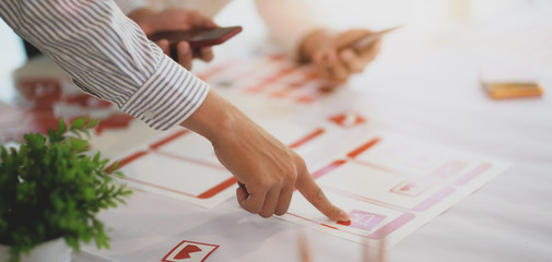 Cropped shot of young professional UX web developer working on smartphone