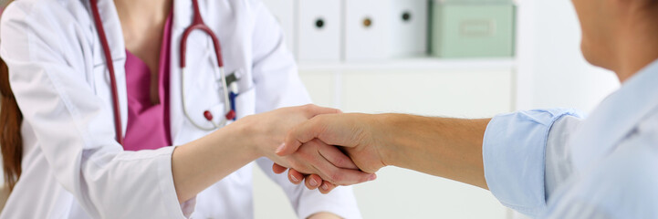 Wall Mural - Female medicine doctor shake hand as hello with male patient