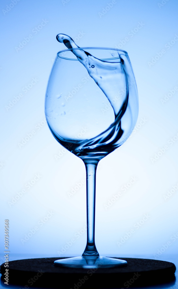 a splash of liquid in a glass wine glass. water pouring inside a glass wine  glass.