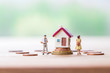 © pim pic - selective focus of miniature angry woman with miniature man and mini house on stack coins over blurred green garden background  for Asset management after divorce concept.