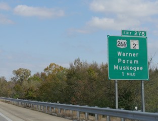 Road sign and direction to the exit for Warner, Porum and Muskogee, Oklahoma.