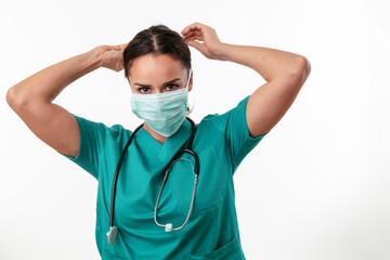 Wall Mural - Beautiful female doctor in green uniform. Portrait of nurse with mask