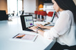 © BullRun - Young businesswoman using laptop in office