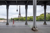 Fototapeta Paryż - Woman walking under the Bir-Hakeim metro bridge in Paris