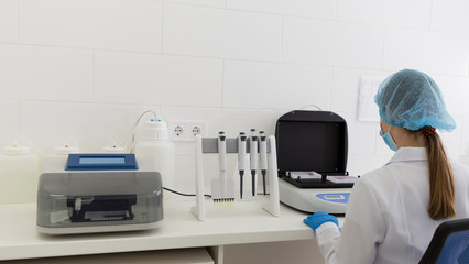 Poster - Unrecognizable woman in medical wear working in modern lab