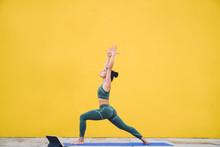 Fit Woman Meditating In Yoga Posture With Arms Raised