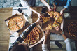 © BullRun - Friends taking out slices of pizza from box at table