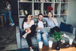 © BullRun - Group of young hipsters laughing and sitting on couch
