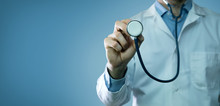 Healthcare And Medicine - Doctor In White Coat Holding Stethoscope On Blue Background. Copy Space