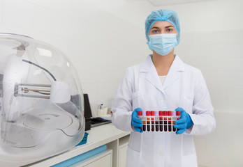 Poster - Woman in medical wear preparing blood samples in test tubes
