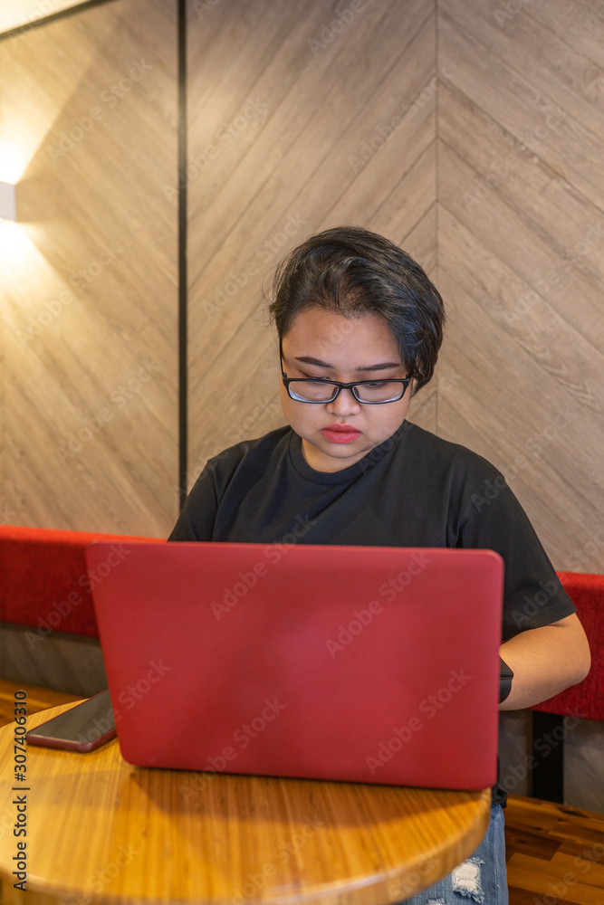 Asian modern female freelancer using laptop at cafeteria - obrazy, fototapety, plakaty 