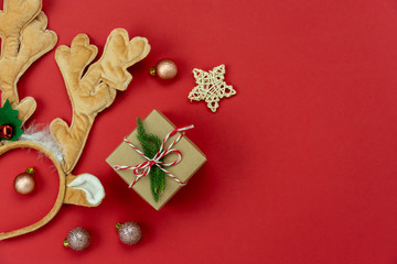 Wall Mural - Table top view of Merry Christmas decorations & Happy new year ornaments concept.Flat lay essential difference objects gift box & fir tree on modern red paper background at home studio office desk.