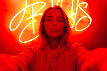 Poster - Image of young caucasian woman standing over red neon text sign outdoors