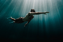 Man Swimming Underwater In Ocean