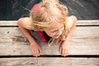 © Cavan Images - Child Smiling While Swimming at a Lake near a Dock