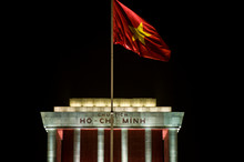 Ho Chi Minh Mausoleum At Night And Vietnam Flag Fluttering In The Wind