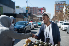 Man Buying Fruit From A Street Vendor In Johannesburg