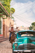 Cuba classic car with horse rider