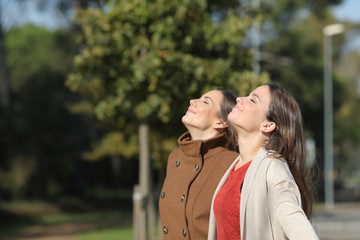 Poster - Two relaxed women breathing fresh air in winter in a park