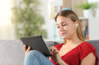 © Antonioguillem - Woman e-learning using tablet and earphones at home