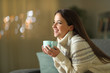 © Antonioguillem - Happy woman holding coffee cup in winter at home