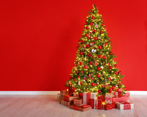 Wall Mural - christmas tree on the background of red empty wall.