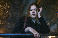 Portrait Of Young Woman Looking Through Wet Glass