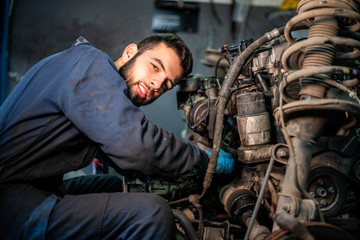 Car service and maintenance: an automechanic is repairing a vehicle