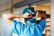 © Santi Nunez/Stocksy - Back view of doctor covering her face with surgical mask