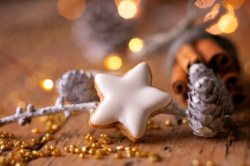 Wall Mural - closeup of homemade cinnamon cookie on rustic wooden table with bunch of cinnamon sticks - christmas