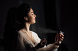 Female beauty. Lovely woman at home. Bride spray perfume stylish woman wearing a white dress spray tender perfume. Stylish glass bottle of perfume in hands. Girl with makeup and a bottle of perfume