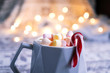Cup of hot chocolate with marshmallows and candy cane. Lifestyle, christmas photo with bokeh