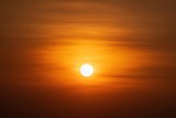 Fototapeta Zachód słońca - Beautiful sunset over sea. Tranquil scene of Closeup red sun and red sky sunset over the ocean