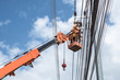 © phoderstock - Two electrician workers are climbing on the electric poles to install and repair power lines.