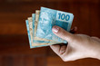 Hands holding Brazilian real notes - Money from Brazil - Notes of Real - Brazil BRL banknote
