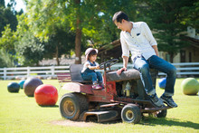 Asian Daughter And Father Are Playing By Driving Tractor Together In The Farm, Concept Of Love And Relation In Family And Learning By Playing For Kid.
