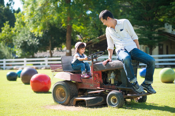 Wall Mural - Asian daughter and father are playing by driving tractor together in the farm, concept of love and relation in family and learning by playing for kid.