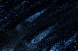 Splash of blue sparkles on black background. Color of the year 2020 concept.