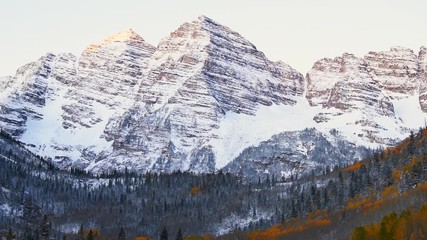 Wall Mural - Maroon Bells morning sunrise timelapse with yellow sunlight on peak in Aspen, Colorado rocky mountain and autumn foliage view closeup and winter snow