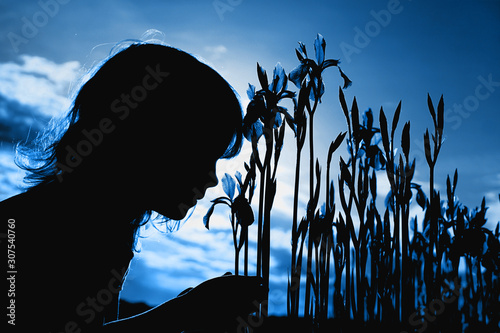 Fotografía A little girl sniffs iris flowers. Color of year 2020.