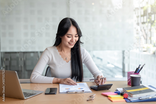 Cuadros en Lienzo Business women using calculator at working with financial report.