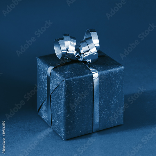 Classic gift box on blue background. Minimal styled holiday concept. Shot at ...