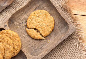 Wall Mural - Homemade oat and wholemeal biscuits  on brown wooden tray. Its are a nutrient-rich food associated with protein, fiber and no artificial flavours or colour added.