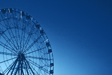 glowing lights on the ferris wheel, resort nightlife, background, blue beautiful sky