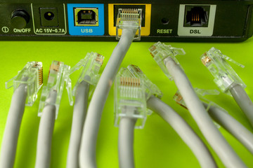 The struggle for a place in the network. Among the many network wires, one winner received a place in the LAN connector of the router. Close-up, selective focus on the router.