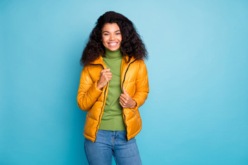 Poster - Photo of amazing dark skin curly lady in good spring mood going outside for walk wear trendy yellow fall overcoat jeans green pullover isolated blue color background