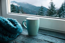 Winter Background - Cup With Candy Cane, Woolen Scarf And Gloves On Windowsill And Winter Scene Outdoors. Still Life With Concept Of Spending Winter Time At Cozy Home With Cold Weather Outdoors