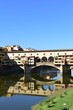 Ponte Vecchio and Arno River with blue sky and water reflection. Florence, Italy.