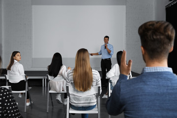 Canvas Print - Male business trainer giving lecture in conference room with projection screen